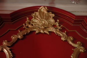 The top ornament of a decorative 18th Century style mirror ensemble